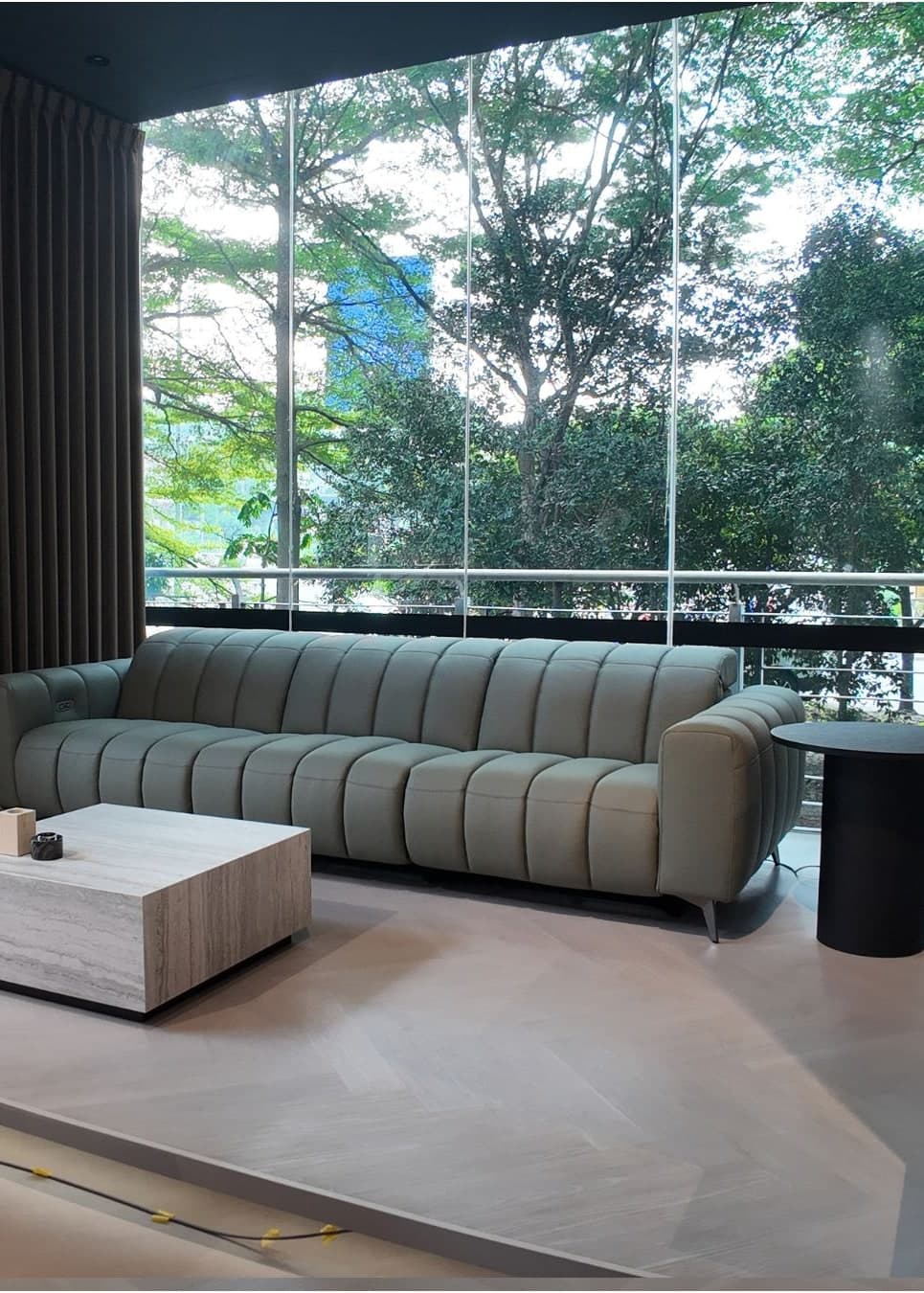 Sage channel-tufted sofa by the floor-to-ceiling windows of the Bangsar showroom